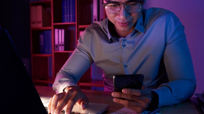 Hombre usando teléfono y portátil