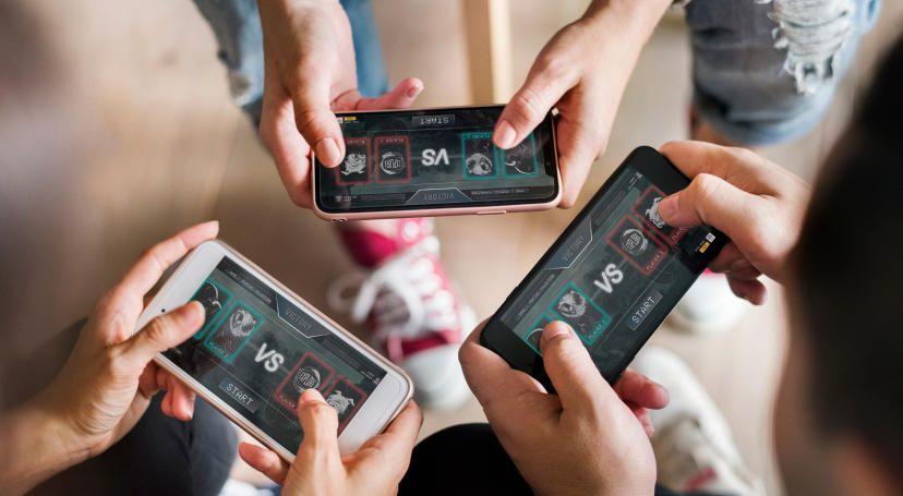 Three people holding devices