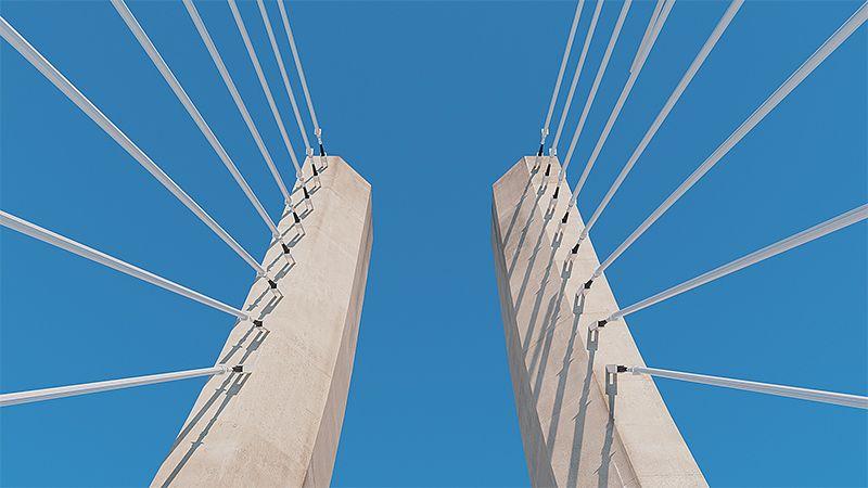 Cabos em uma ponte vistos por baixo em um céu azul claro